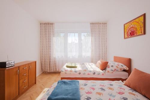 科希策Terasa Capajevova 6 Kosice的一间卧室配有一张床、一个梳妆台和一扇窗户。