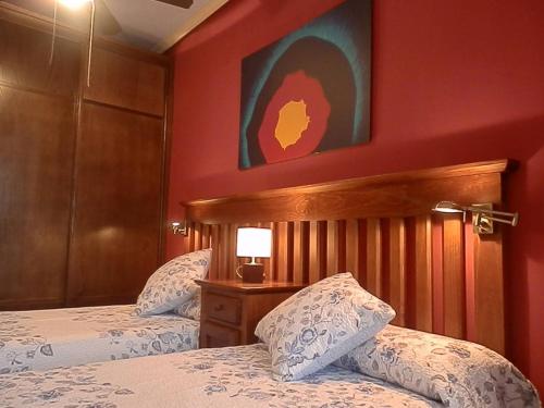 乌贝达-2-COMO EN CASA, en centro historico de Ubeda的一间卧室设有两张床和红色的墙壁