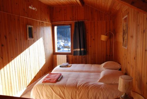 蒙热内夫尔grand chalet plein sud的木制客房内的一间卧室,配有一张床