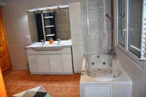 奥瓦伦纳茨Chalet Belmont的带浴缸、水槽和淋浴的浴室