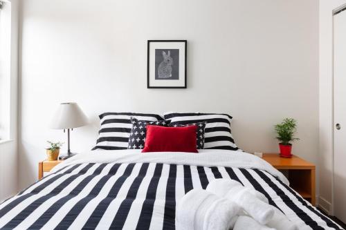 芝加哥Uptown Gem的卧室配有黑色和白色的床和红色枕头
