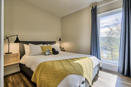 圣阿黛拉Modern Chalet with Mountain and Lake view by Reserver.ca的一间卧室设有一张床和一个大窗户