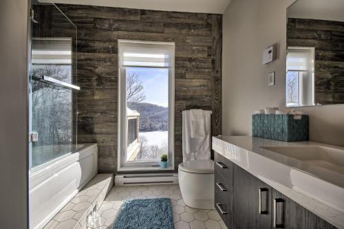 圣阿黛拉Modern Chalet with Mountain and Lake view by Reserver.ca的一间带水槽和卫生间的浴室以及窗户。