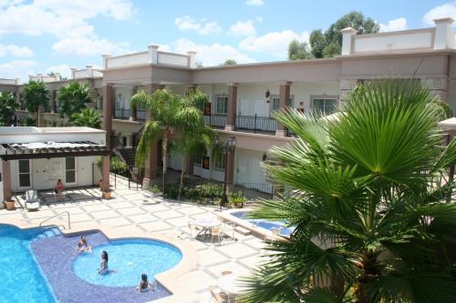 埃莫西约皇宫酒店的享有带游泳池和棕榈树的建筑的空中景致
