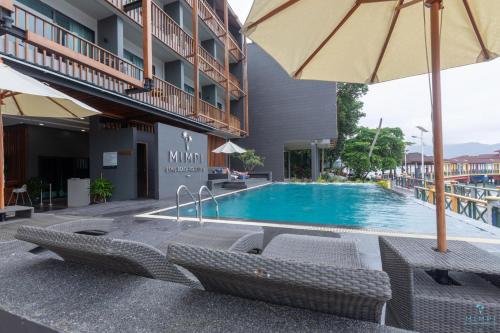 停泊岛敏披佩汉田安度假村的酒店设有带椅子和遮阳伞的游泳池