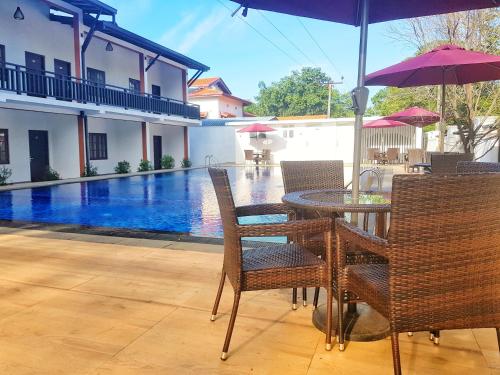 卡特勒格默Livinya Holiday Resort的桌椅、遮阳伞和游泳池