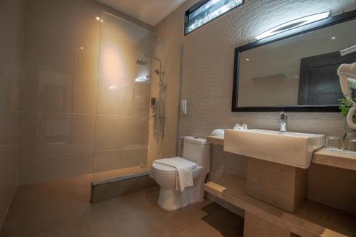 特鲁克巴库民丹岛别墅海滩温泉度假酒店的一间带水槽、卫生间和镜子的浴室