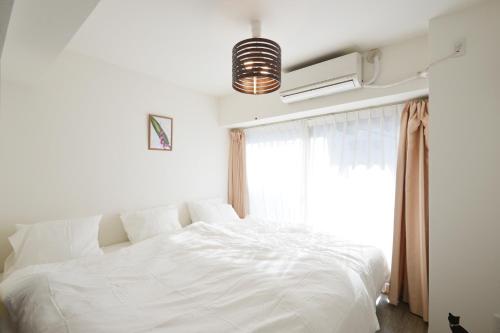 东京Roppongi Cat House601的卧室内的一张白色床,设有窗户