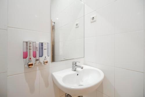马卡萨RedDoorz Plus @ Karebosi Area 2的白色的浴室设有水槽和镜子