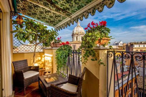 罗马鲜花广场精品酒店的阳台设有椅子和植物,享有建筑的景色
