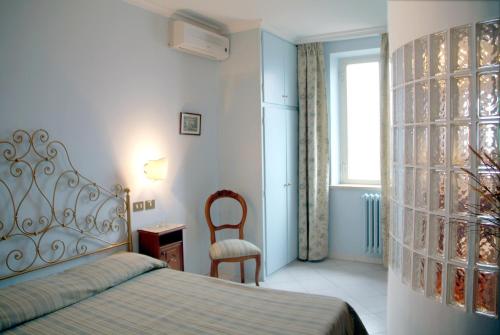 冈多菲堡卢西亚庞内里住宿加早餐旅馆的卧室配有床、椅子和窗户。