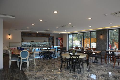 伯萨Eleia Hotel İznik的用餐室设有桌椅和窗户。