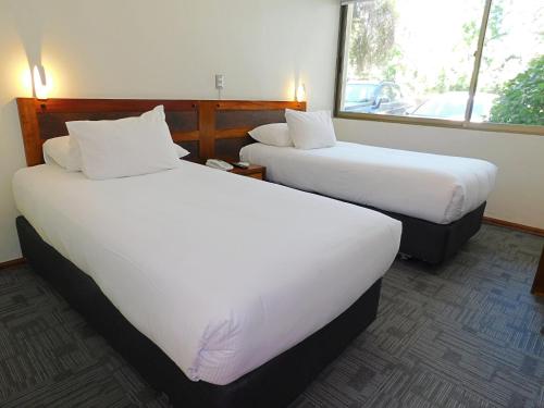 兰卡瓜安第斯海酒店的配有白色床单的酒店客房内的两张床