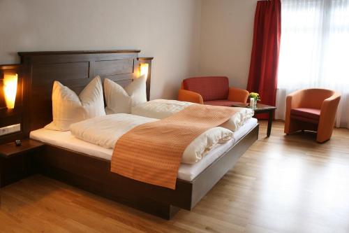 阿尔皮尔斯巴赫Löwen-Post的一间卧室配有一张大床和一把椅子