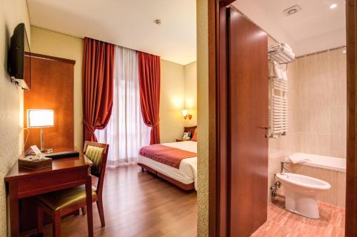 罗马奥古斯塔鲁西拉宫酒店的酒店客房设有一张床、一张书桌和一间浴室。