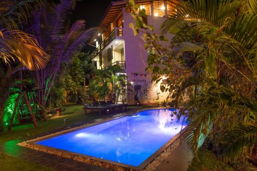 希克杜沃芬兰卡酒店 的夜间在房子的院子中的一个游泳池