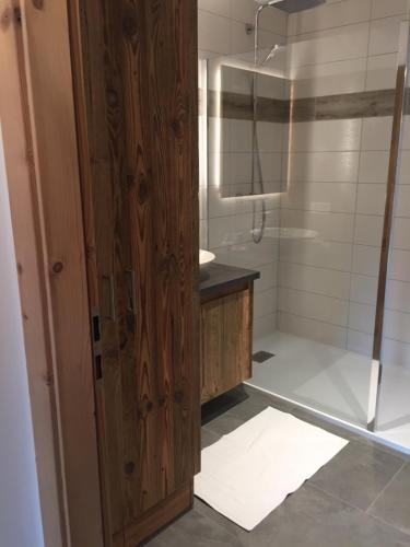 拉布雷斯LA BRESSE - Appartement de Charme的带淋浴的浴室和木门。