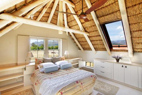 弗朗斯胡克Villa Simondium的一间带一张大床的卧室,位于一个拥有木制天花板的房间