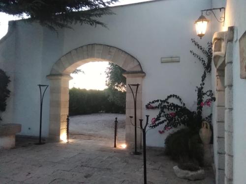 奥里亚Masseria Lapica的带有拱门的白色建筑的入口