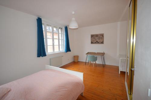 圣康坦La Cotonnerie的一间卧室配有一张床、一张桌子和一个窗户。