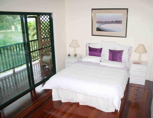 霍斯舒湾True North B&B的一间卧室配有一张带紫色枕头的床和一个阳台