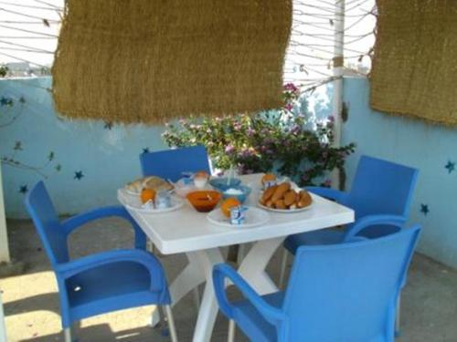 卢克索卢克索鲍勃马利酒店的一张带蓝色椅子的白色桌子和食物