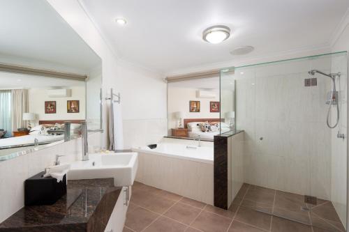 RhyllLuna Blu - Luxury B&B的带浴缸、水槽和淋浴的浴室