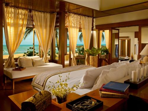 龙运Tanjong Jara Resort - Small Luxury Hotels of the World的一间卧室配有一张床,享有海景