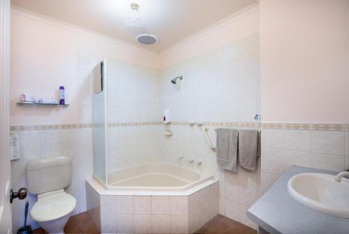 芒特甘比尔Mid City Motel的带浴缸、卫生间和盥洗盆的浴室