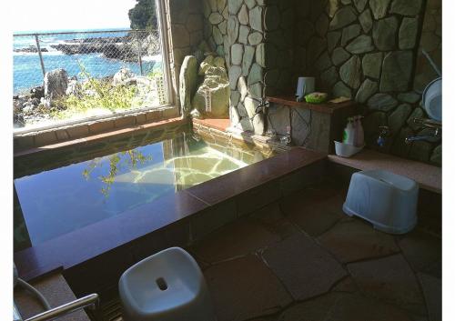 周参见町海のお宿的带浴缸、卫生间和窗户的浴室