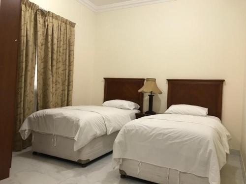 沙迦Al Majarah Residence的卧室内两张并排的床