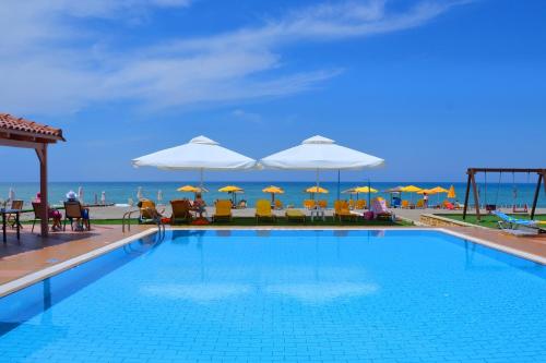 阿德里安诺斯坎波斯Galeana Mare Hotel Apartments by Gasparakis的海滩上带椅子和遮阳伞的游泳池