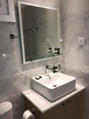 布卡里阿克吉利旅馆的浴室设有白色水槽和镜子