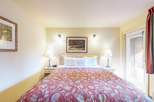 莱文沃思Aspen Suites 506: The Nest的一间卧室配有一张床、两盏灯和一个窗户。