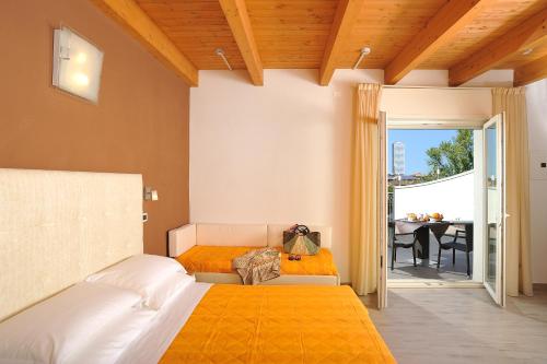 切塞纳蒂科法沃尔利塔酒店的一间卧室配有一张床,阳台配有桌子
