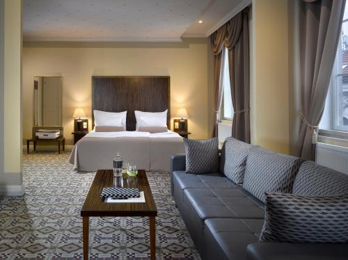 布尔诺格兰迪萨豪华宫殿酒店的酒店客房,配有床和沙发