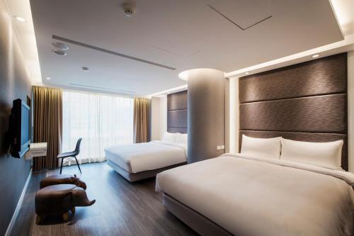 台北蒲园饭店的酒店客房,配有两张床和椅子