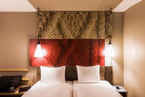 朴次茅斯朴次茅斯宜必思酒店的墙上画画的房间里设有两张床