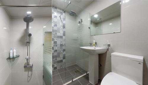江陵市Gyeongpoen Pension的浴室配有卫生间、盥洗盆和淋浴。