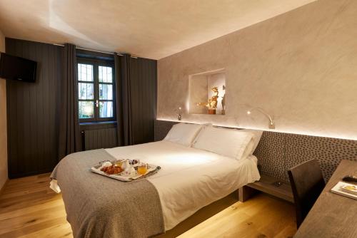 Gignod拉克吕萨洛坎达酒店的一间酒店客房,配有一张床铺,上面放着一个食物托盘