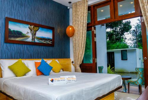 阿努拉德普勒Hotel Bella Vista的卧室配有一张床,墙上挂有绘画作品