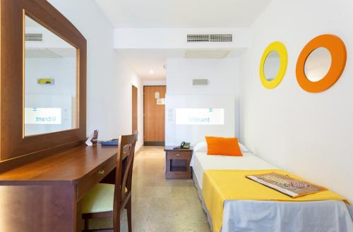 马贝拉全球科尔蒂霍布兰科酒店的一间卧室配有书桌、一张床和镜子