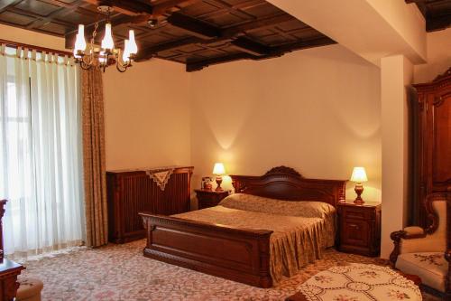 阿尔巴尤利亚中世纪酒店的一间卧室设有一张床和一个大窗户