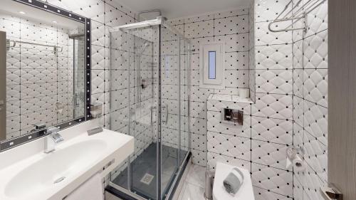 塞萨洛尼基Luxury Living Apartments and Spa的带淋浴、盥洗盆和镜子的浴室