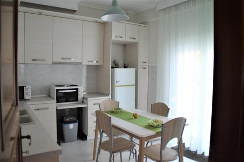 塞萨洛尼基Aigaiou House的厨房配有桌椅