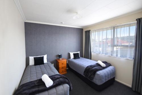 但尼丁ASURE Adrian Motel的酒店客房设有两张床和窗户。
