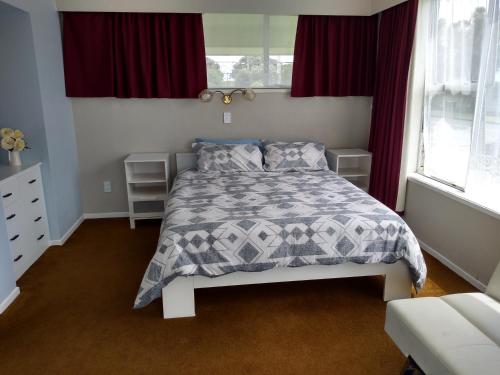 PateaIronsands B&B的卧室配有一张带灰色和白色棉被的床