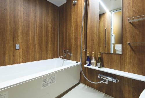 恩纳Hotel Sunset Hill的带浴缸、水槽和镜子的浴室