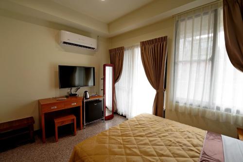 中坜鸿福优雅商旅的配有一张床和一台平面电视的酒店客房