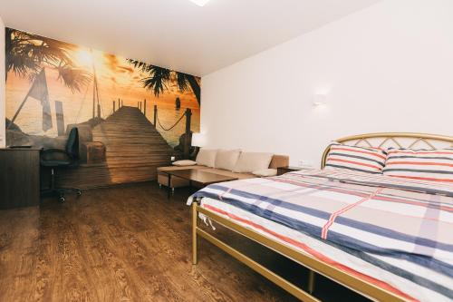 苏梅Apart-Hotel的卧室配有一张床,墙上挂有绘画作品